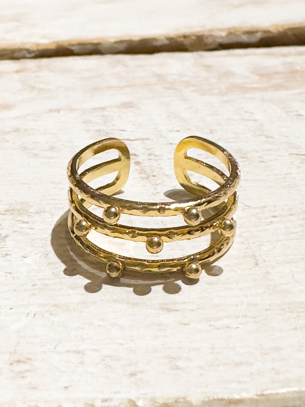 Anillo acero dorado tres rayas bolitas