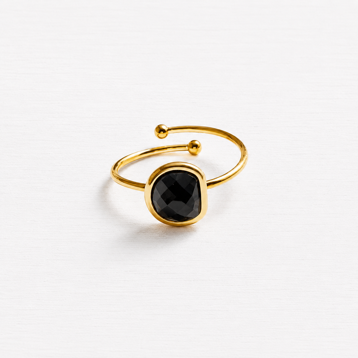 Anillo acero dorado semicírculo piedra facetada negra